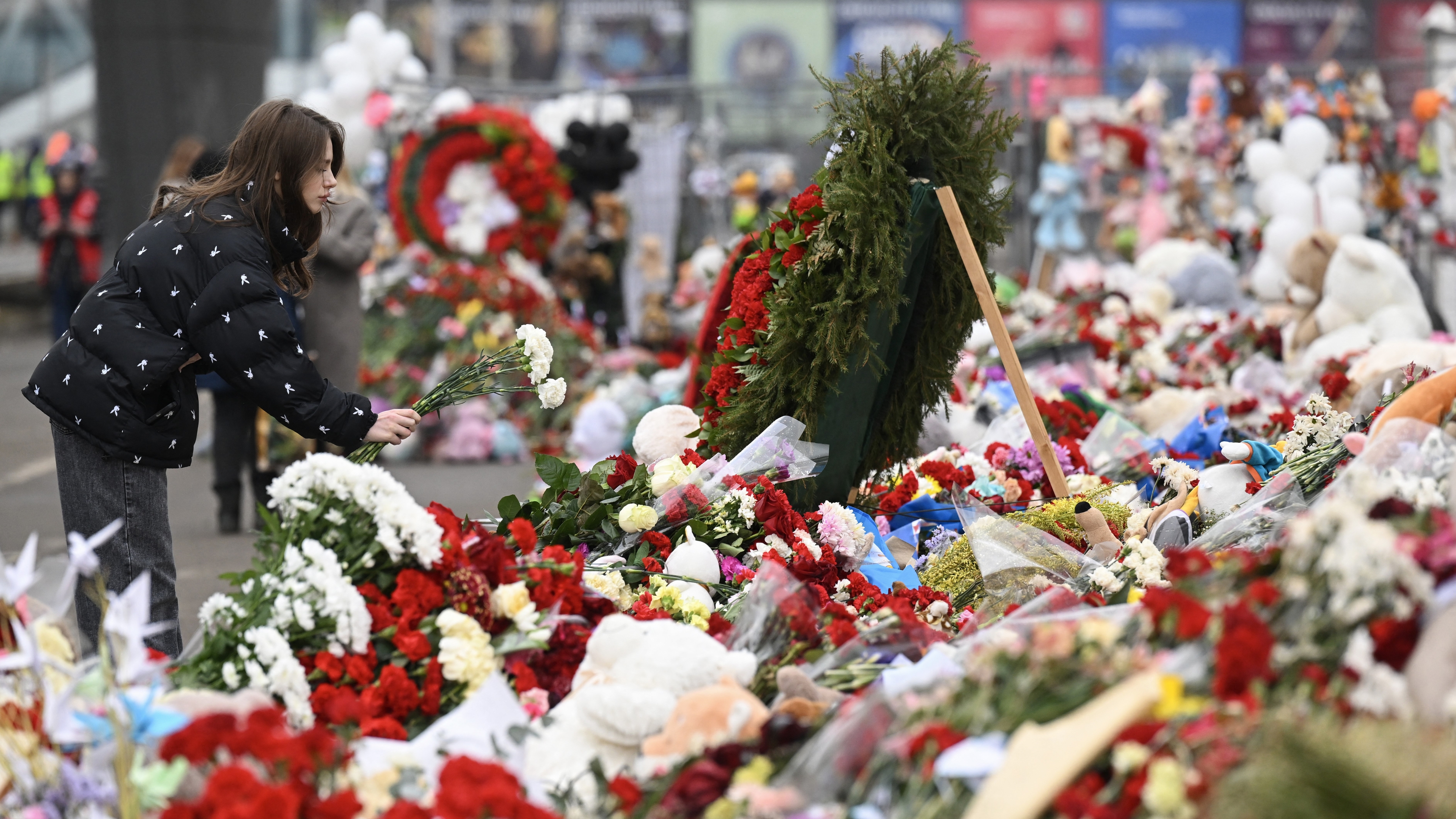En kvinna lägger ner blommor vid Crocus City Hall i Moskvas norra förort Krasnogorsk den 29 mars, en vecka efter den dödliga terrorattacken där. Foto: Natalia Kolesnikova/AFP via Getty Images