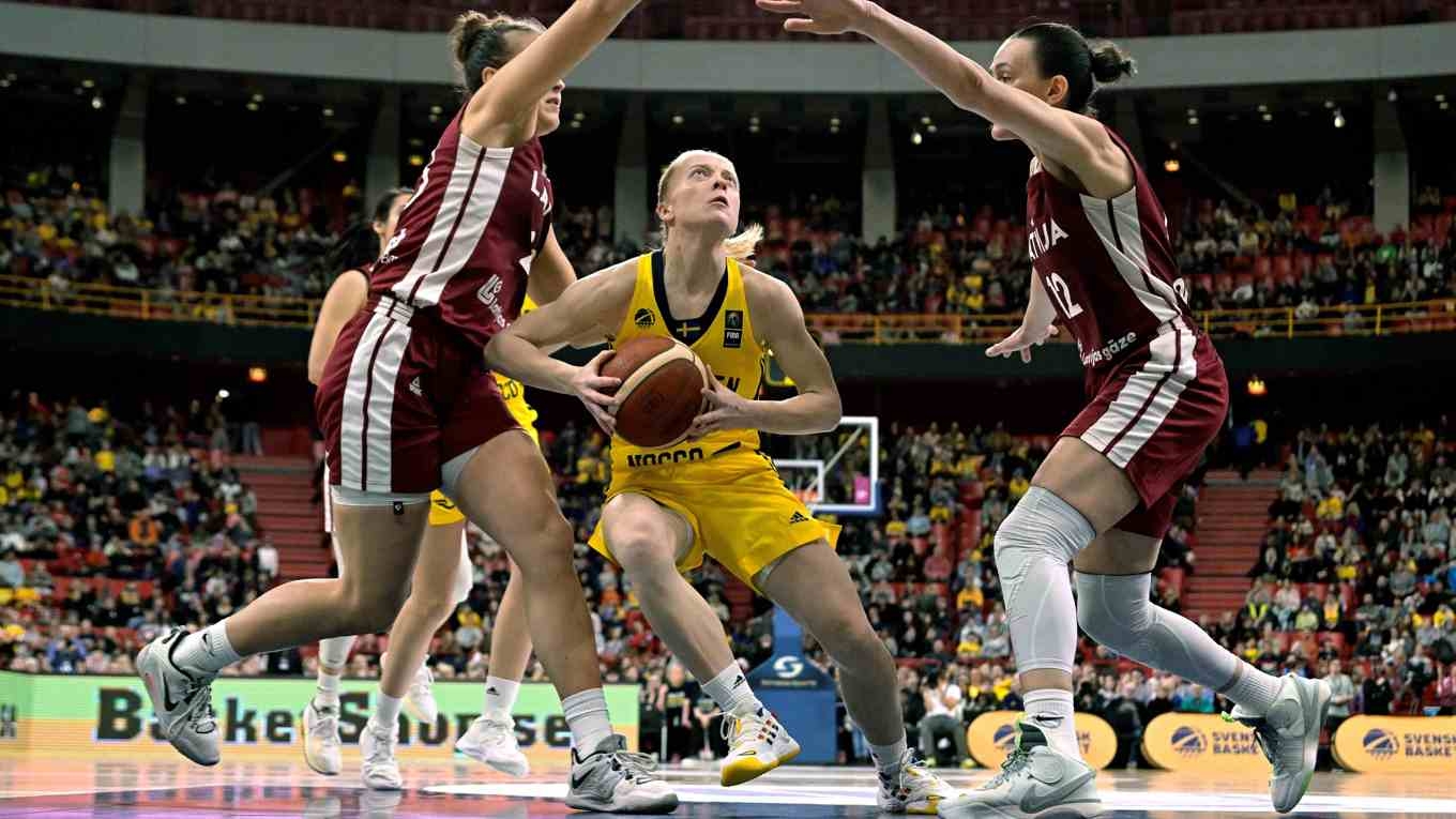 Klara Lundquist gör en layup mellan två lettiska försvarare i EM-kvalmatchen i damernas basket mellan Sverige och Lettland i Avicii Arena. Foto: Janerik Henriksson/TT