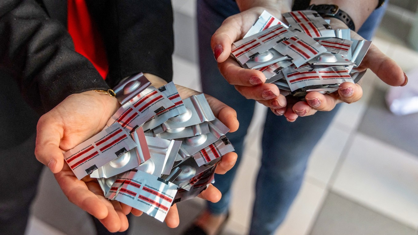 En polsk och en fransk kvinna håller fram aborttabletter vid ett konsultationsställe för abort i Warszawa i Polen. Foto: Wojtek Radwanski/AFP via Getty Images