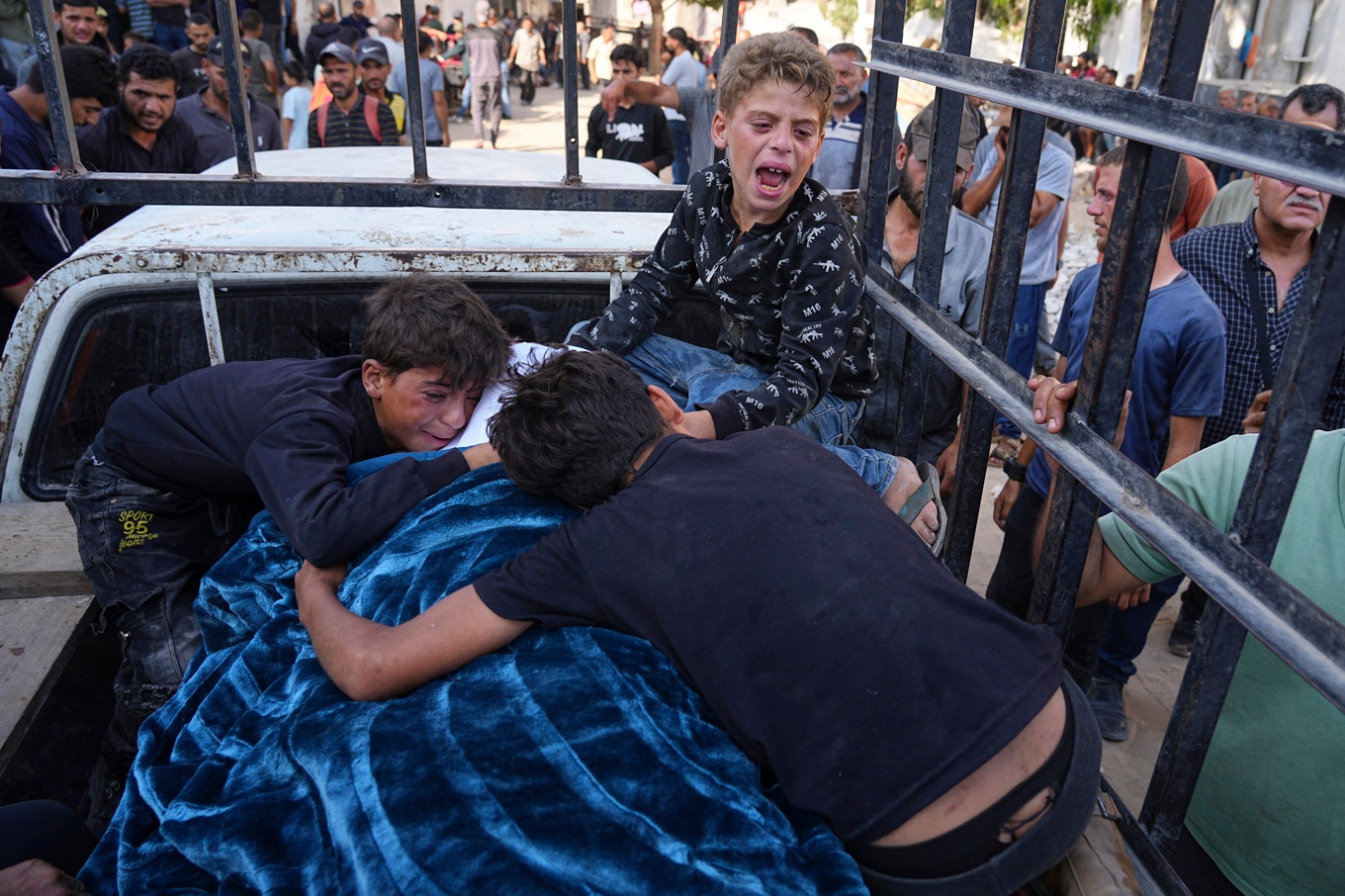 Tre barn sörjer sin pappa, Mohammed Ghaben, som dödats vid en matutdelning i Gaza på onsdagen. Foto: Jehad Alshrafi/AP/TT