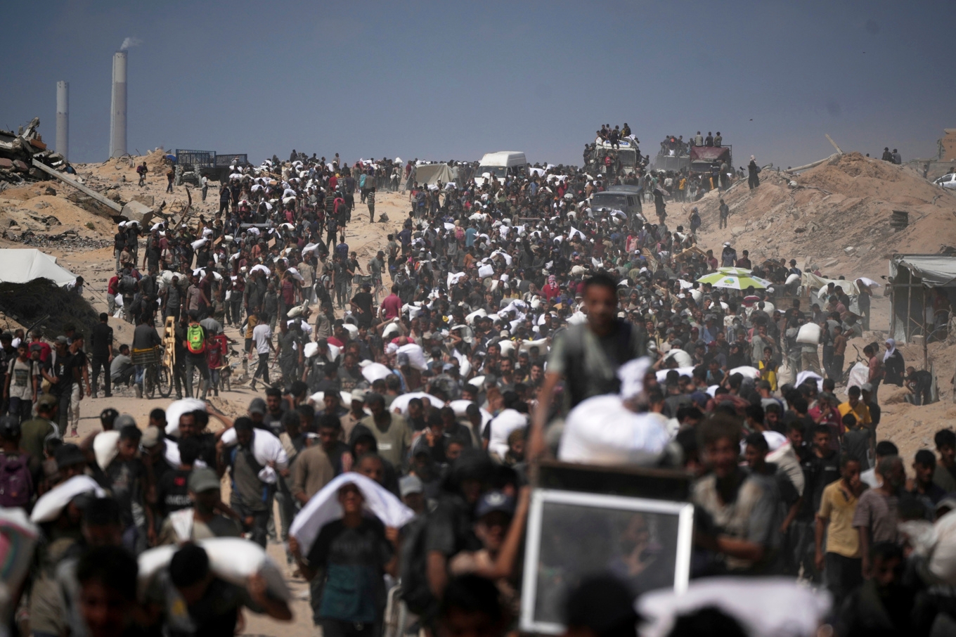 Palestinier som bär på förnödenheter som levererades på fredagen. Foto: Jehad Alshrafi/AP/TT
