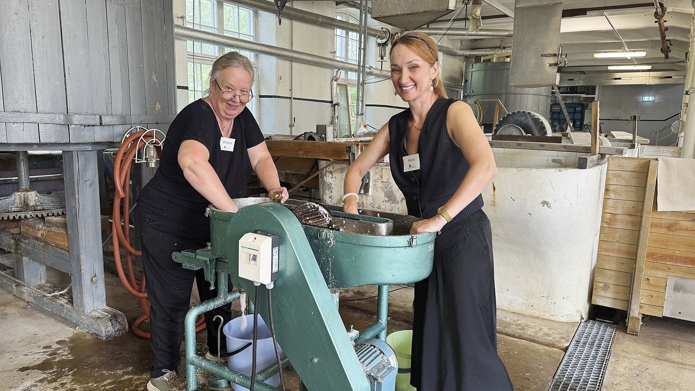 Guiderna Christina Gutiérrez Malmbom och Astrid Raabe håller workshops i papperstillverkning. Här maler de bomullstyg till pappersmassa i den lilla holländaren. Foto: Anton Anderberg