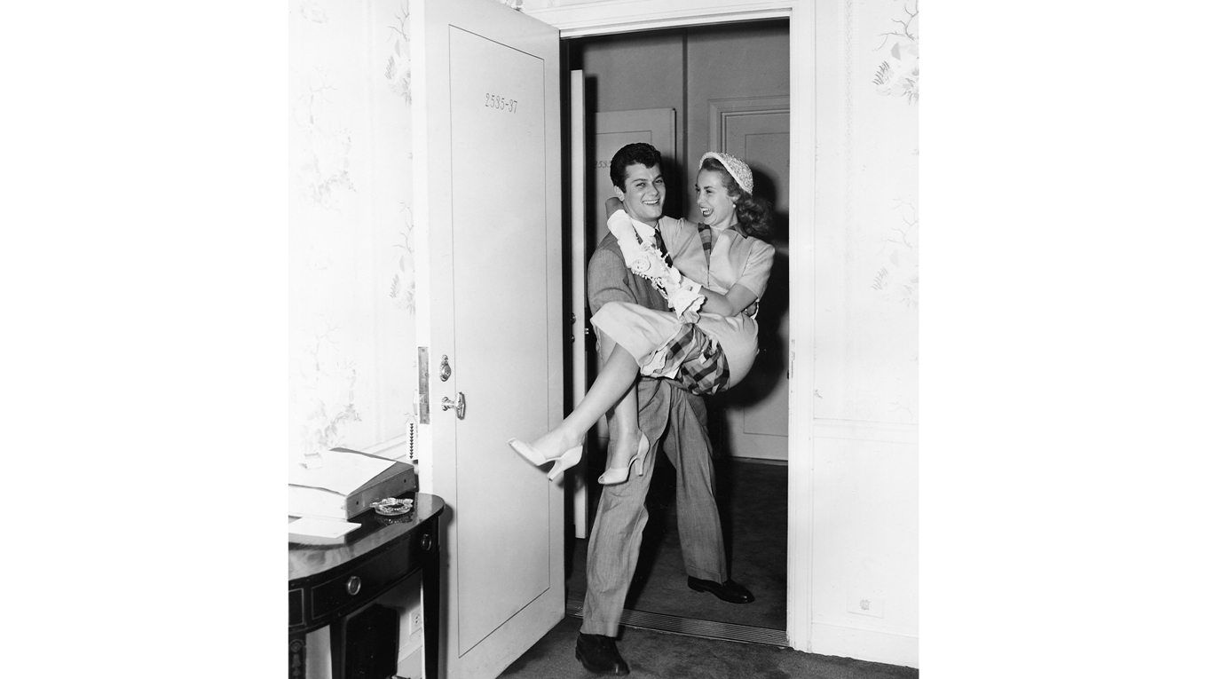 Tony Curtis bär sin nyblivna fru Janet Leigh in i bröllopssviten på Waldorf Astoria den 4 juni 1951. Foto: AP/TT BILD