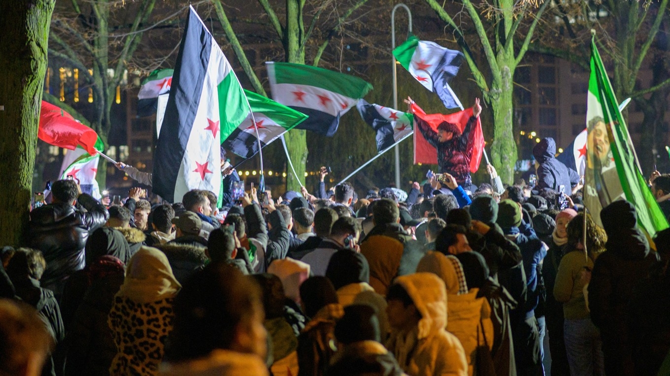 Människor viftar med den syriska oppositionens revolutionsflagga för att fira Bashar al-Assads och den syriska regimens fall under en demonstration i Berlin i Tyskland den 8 december 2024. Foto: Stefan Frank/Middle East Images/AFP via Getty Images
