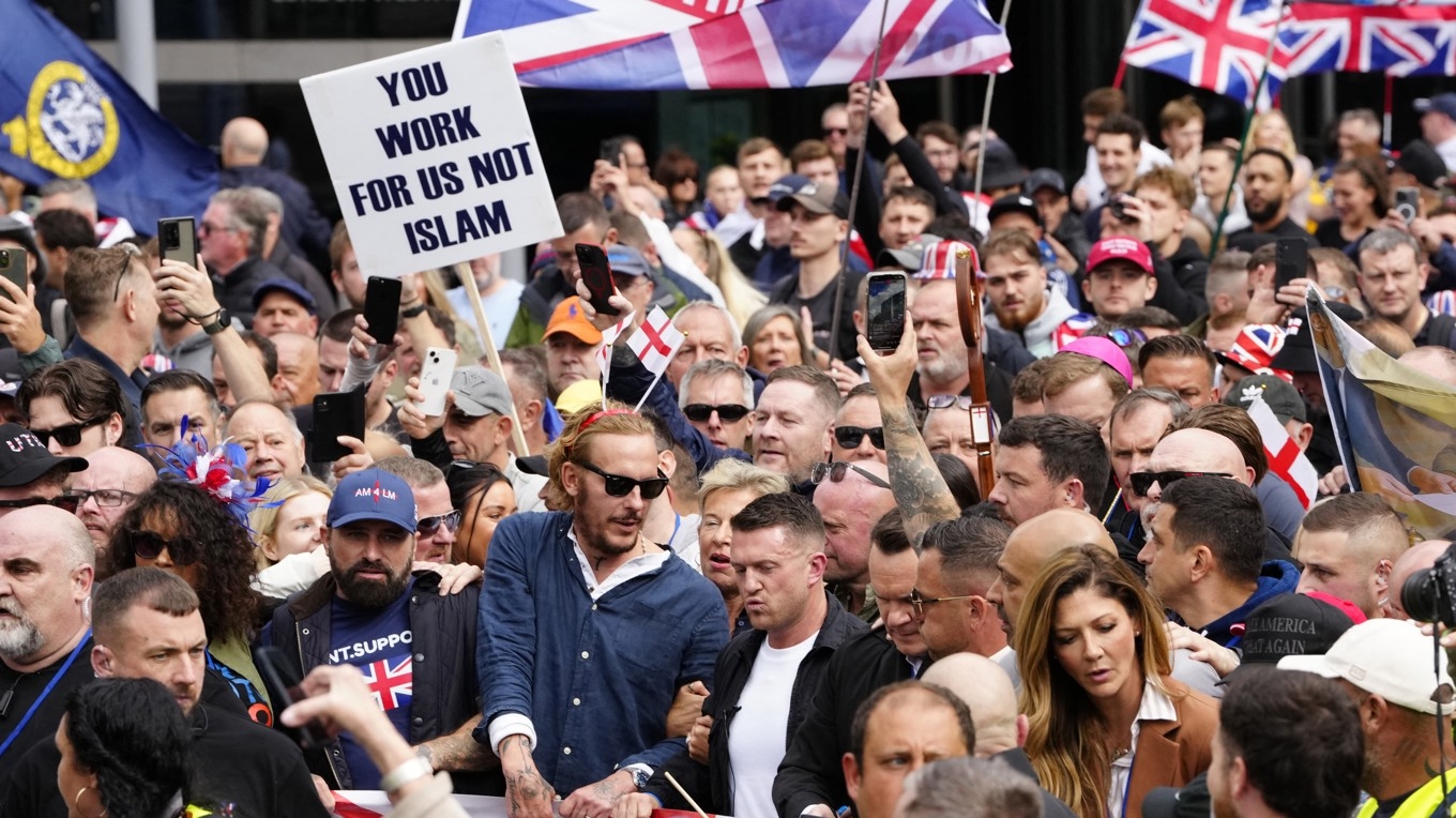 Den brittiske journalisten och invandringskritiske aktivisten Tommy Robinson (i mitten) deltar i en demonstration i London. Foto: Carlos Jasso/AFP via Getty Images