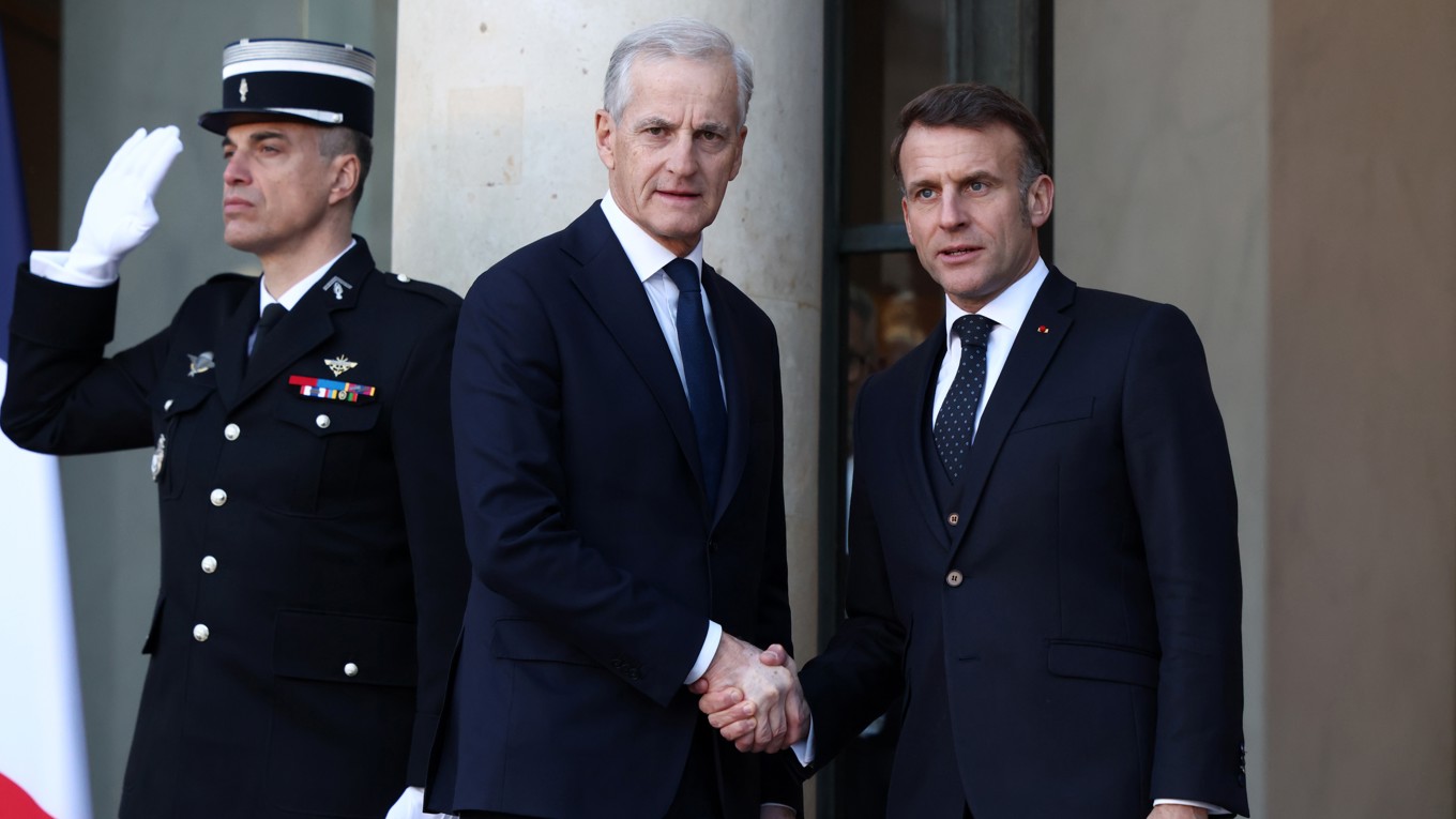 Norges statsminister Jonas Gahr Støre (AP) hälsar på Frankrikes president Emmanuel Macron den 6 januari. Foto: Tom Nicholson/Getty Images