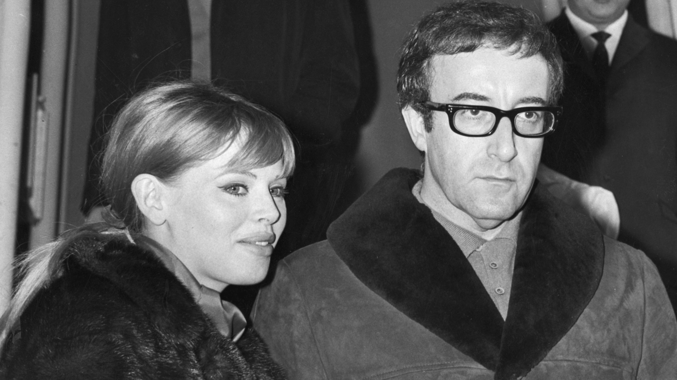 Äkta paret Peter Sellers och Britt Ekland befinner sig på denna bild på resande fot, på Londons flygplats. Är de måhända på väg till Sverige? Kanske har Sellers precis fått höra om årets bistra vinter, för han verkar ju helt klart ha fått kalla fötter. Foto: AP/TT BILD