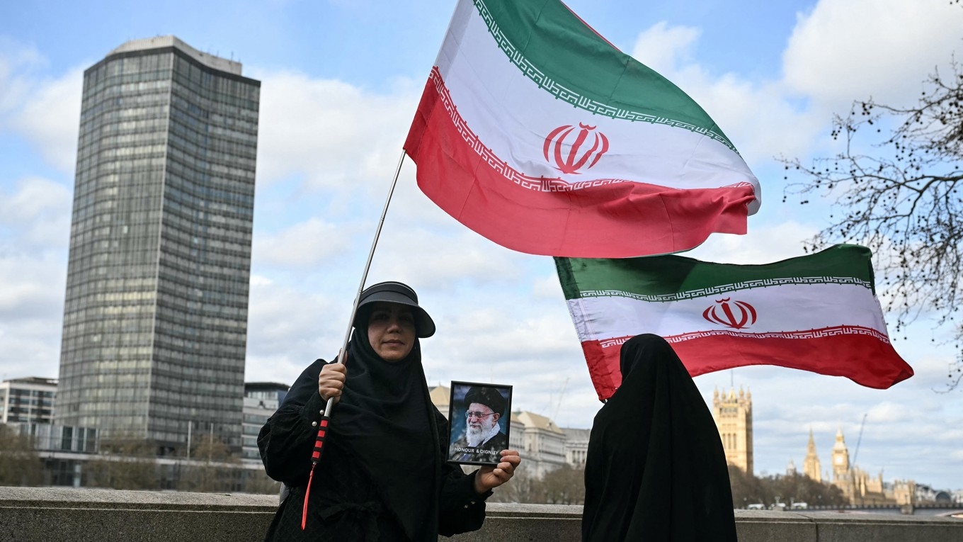Anhängare av den iranska regimen viftar med iranska flaggor i en demonstration i centrala London den 15 mars. Bilden har inget samband med artikeln att göra. Fot: Justin Tallis/AFP via Getty Images