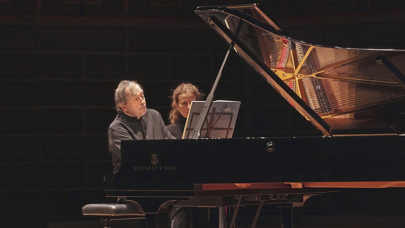 Pierre-Laurent Aimard vid flygeln i Stora salen i Stockholms konserthus, assisterad av sin notvändare. Foto: Nadja Sjöström