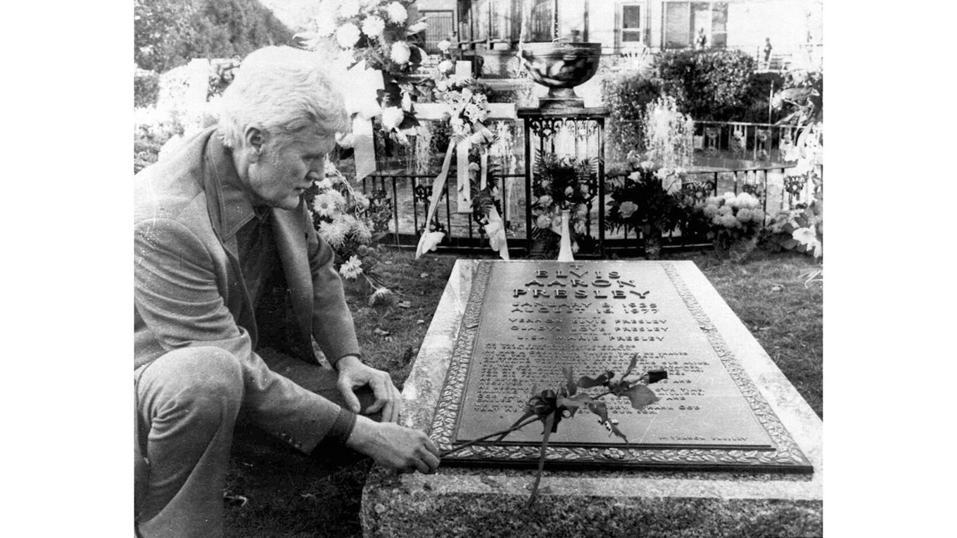 Vernon Presley lägger en ros på sin sons grav på Graceland den 24 november 1977. Foto: AP/TT BILd