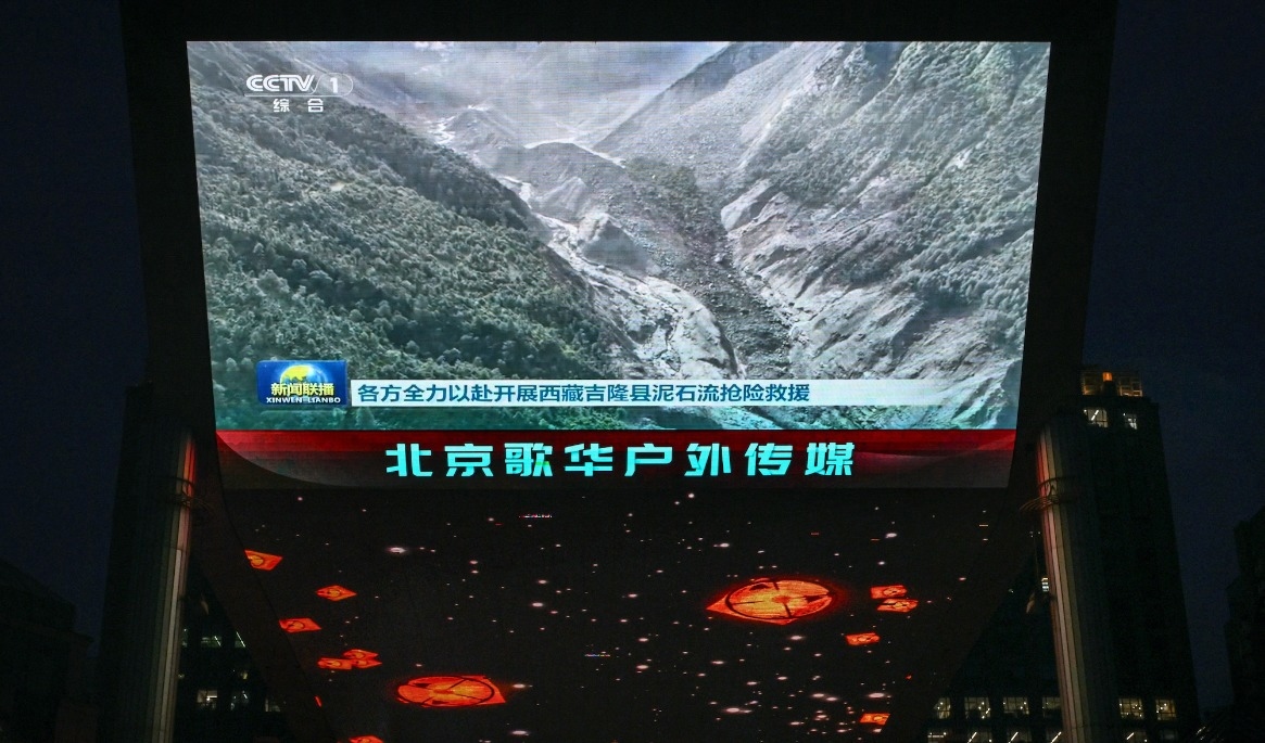 Statliga CCTV visar ett klipp från lerskredet på storskärm i Peking. Informationen har kontrollerats hårt i Kina. Foto: Greg Baker / AFP via Getty Images