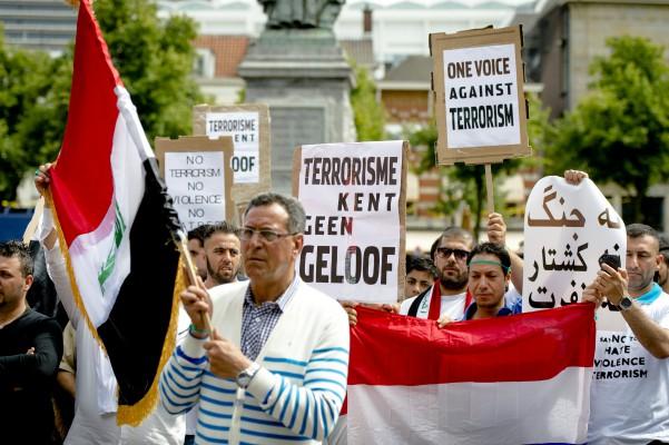 Människor deltar i en demonstration mot den våldsamma jihadistgruppen Islamiska staten för Irak och Levanten (IS eller ISIS), i centrum av Haag, den 29 Juni. På banderollerna står det "terrorism tror inte på religion" och "En enad röst mot terrorismen". Den 29 juni 2014 förklarade ISIS att de hade deklarerat området från Aleppo i norra Syrien till Diyala i Irak till Islamiska staten och kommer att styra det som ett  "kalifat" - en islamisk form av regering som senast sågs under det ottomanska imperiet.  (Foto: Robin Van Lonkhuijzen / AFP / Getty Images)