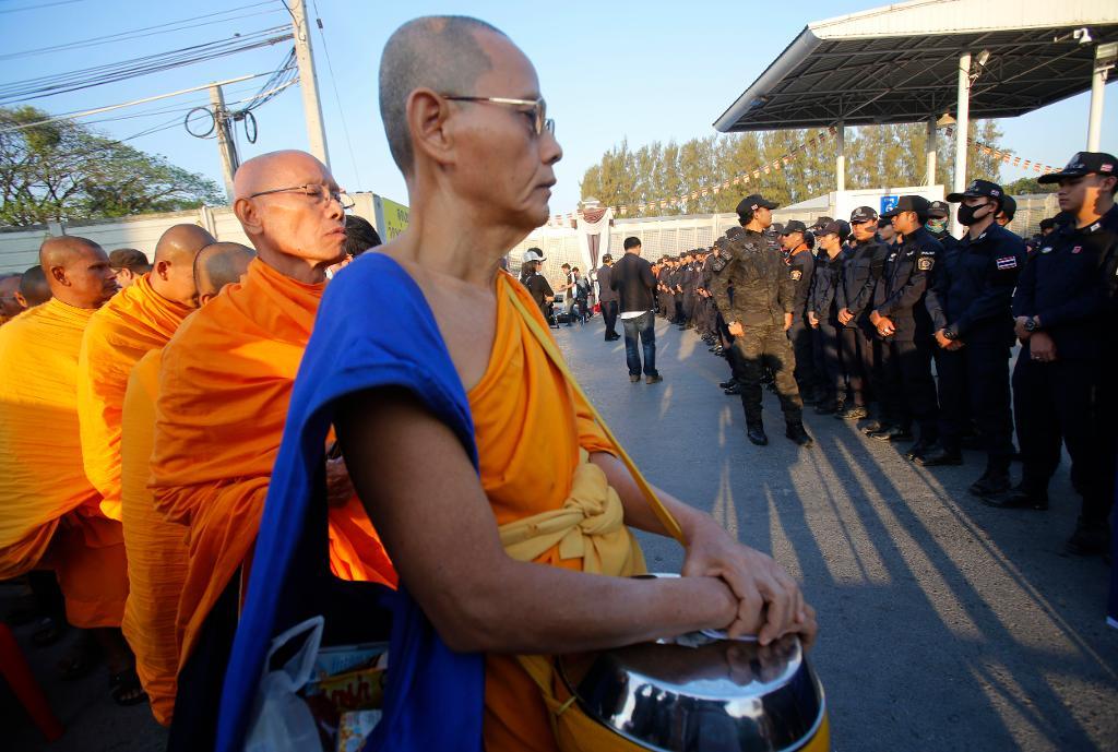 
Munkar står framför poliser utanför tempelområdet Dhammakaya. Foto: Sakchai Lalit/AP/TT
