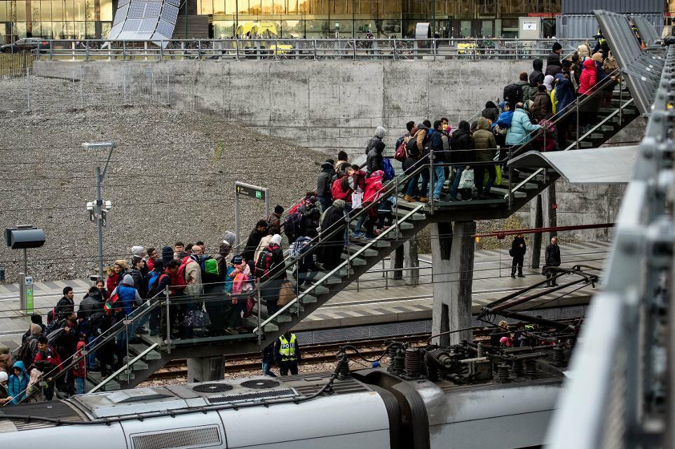 
Polis övervakar kön av ankommande flyktingar vid Hyllie station i Malmö hösten 2015. (Foto: Johan Nilsson/TT
                                            