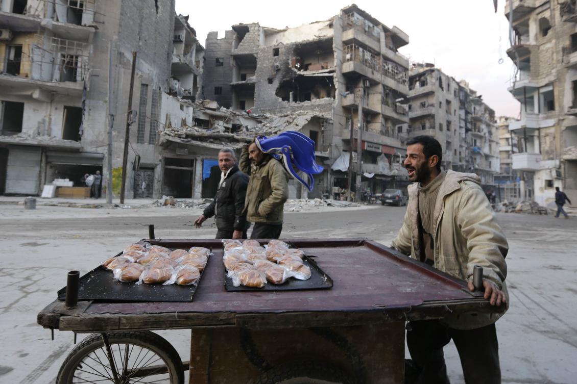 
En gatusäljare säljer croissanter i östra Aleppo som är svårt krigsskadat. Ändå åervänder tusentals invånarna till sin hem där. Foto: Louai Beshara /AFP/Getty Images                                            