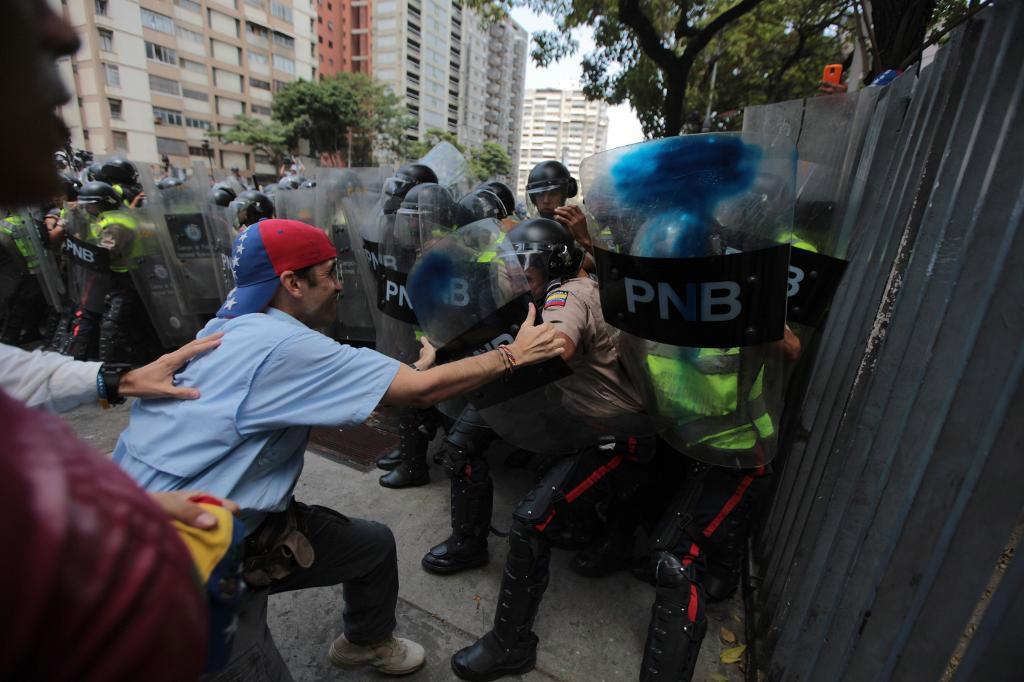Demonstranter och polis drabbar samman i Venezuelas huvudstad Caracas. Foto: Fernando Llano /AP/TT