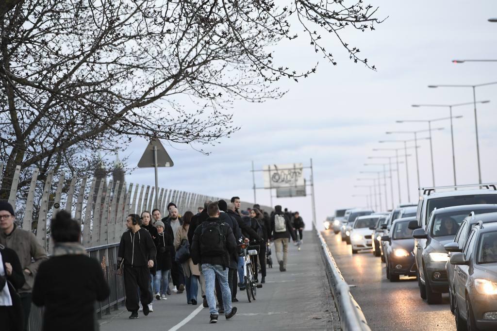 Fotogängare går över Västerbron i Stockholm. När många blev fast i stan erbjöd människor okända sin hjälp på Twitter. Foto: Maja Suslin/TT