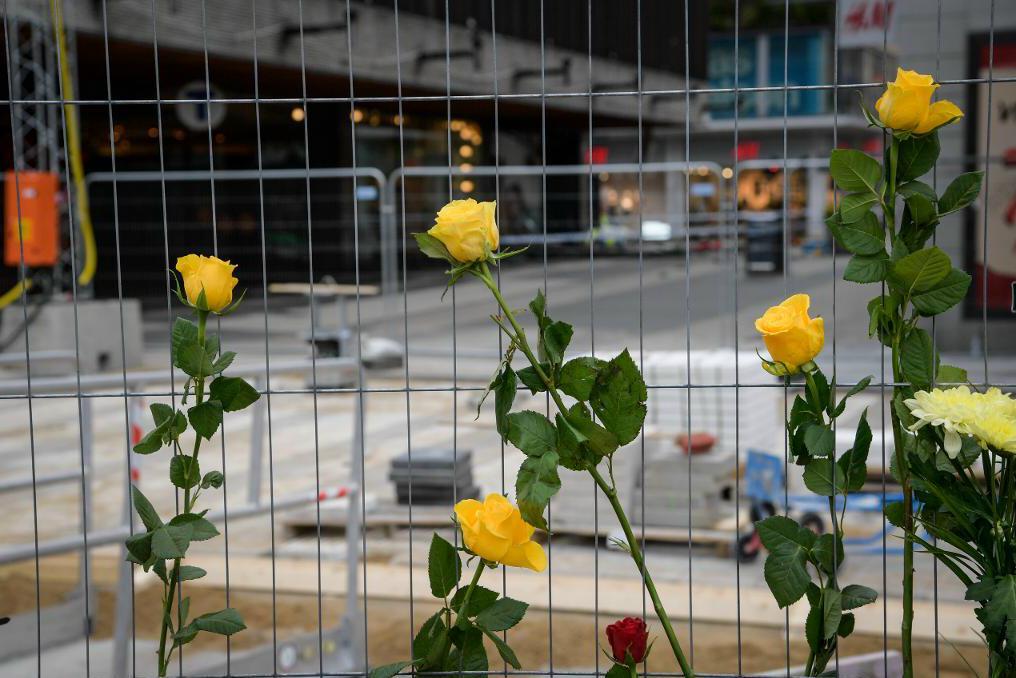 Blommor vid Åhléns i centrala Stockholm. Attacken kommer att uppmärksammas även på andra håll i landet - bland annat vid fotbollsmatchen mellan Eskilstuna och Örebro på Tunavallen. Foto: Anders Wiklund/TT