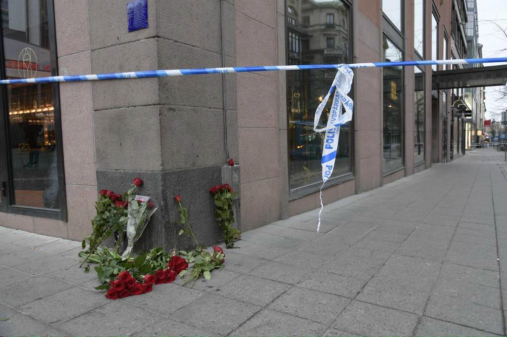 Blommor och ljus vid avspärrningen i hörnet av Hötorget-Kungsgatan på lördagsmorgonen.
Anders Wiklund/TT 
