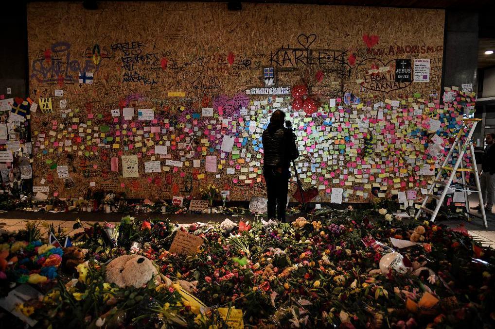 
Blomhav och post-it-lappar med hälsningar vid Åhlens efter terrordådet på Drottninggatan. Foto: Pontus Lundahl/TT-arkivbild                                            