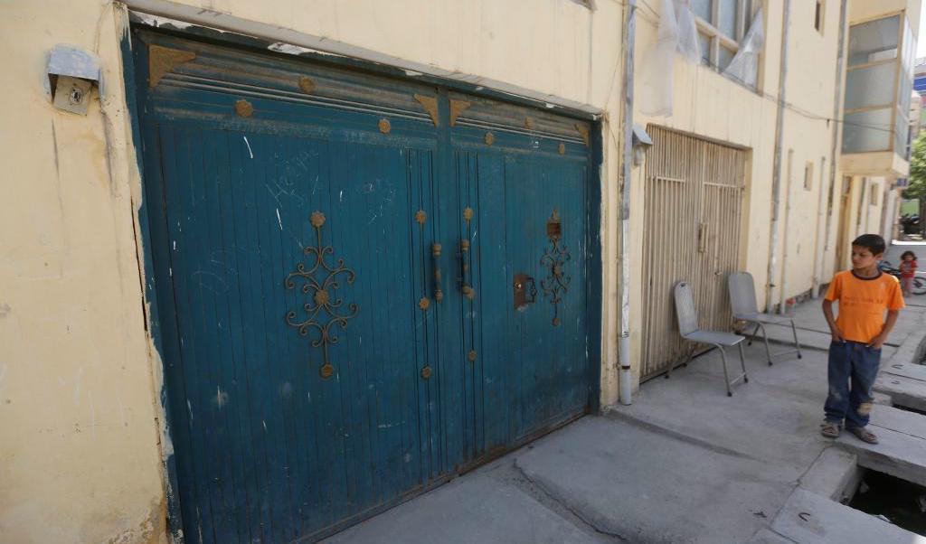 

En afghansk pojke tittar på entrén till det hus i Kabul där en finländsk kvinna blev kidnappad och två andra personer dödades. Foto: Omar Sobhani/Reuters/TT                                                                                        