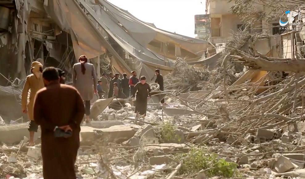 
Människor inspekterar skadorna efter flygräder och artilleribeskjutning i al-Raqqa. Bilden kommer från en film publicerad av IS propagandakanal Amaq. Foto: AP/TT                                            