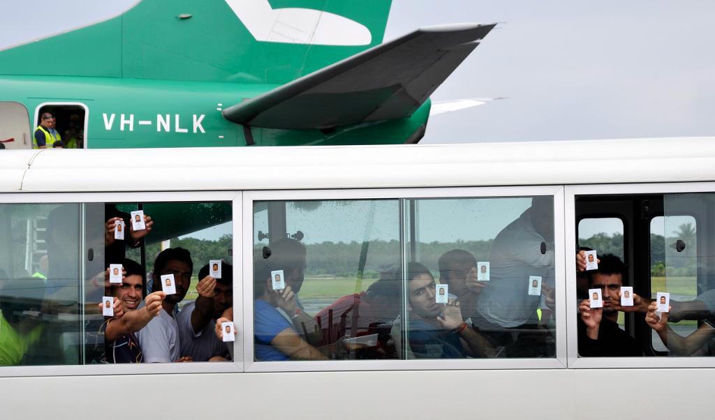 
En grupp asylsökande håller upp sina id-kort efter att ha landat på Manus i Papua Nya Guinea. Foto: Eoin Blackwell/AP/TT-arkivbild                                            