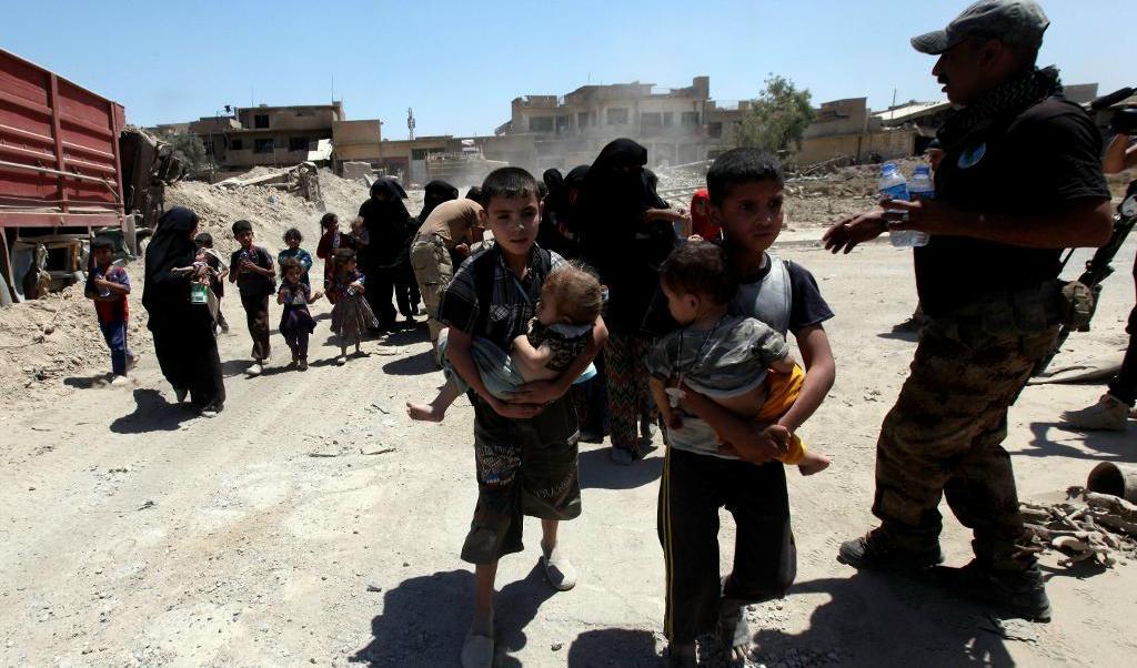 Barn och vuxna flyr under lördagen från gamla Mosul och får vatten och mat av irakiska militären. Foto: Azad Lashkari/Reuters/TT