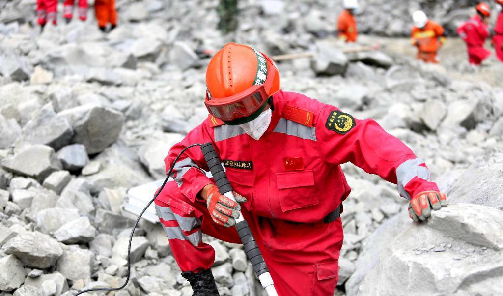 
En räddningsarbetare söker efter överlevande i Xinmo. Foto: Chinatopix/AP/TT                                            