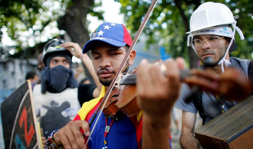 
Wuilly Arteaga har väckt regimens missnöje i Venezuela genom att spela fiol på gatorna under demonstrationer. Han greps i torsdags och ska ställas inför rätta, enligt organisationen Foro Penal. Foto: Ariana Cubillos/AP/TT-arkivbild                                            