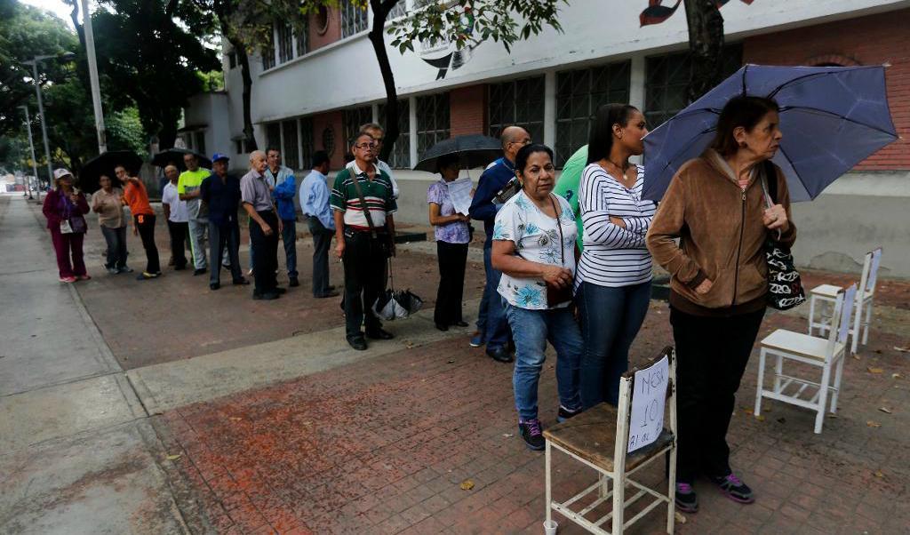 
Venezuelaner väntar på att få rösta vid en vallokal. Foto: Ariana Cubillos/AP/TT                                            