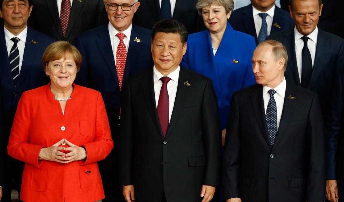 Tysklands förbundskansler Angela Merkel (vä) står bredvid Kinas president Xi Jinping och Rysslands president Vladimir Putin (hö) i ett familjefoto med deltagare från G20-toppmötet i Hamburg den 7 juli 2017. Foto: Odd Andersen/AFP/Getty Images.