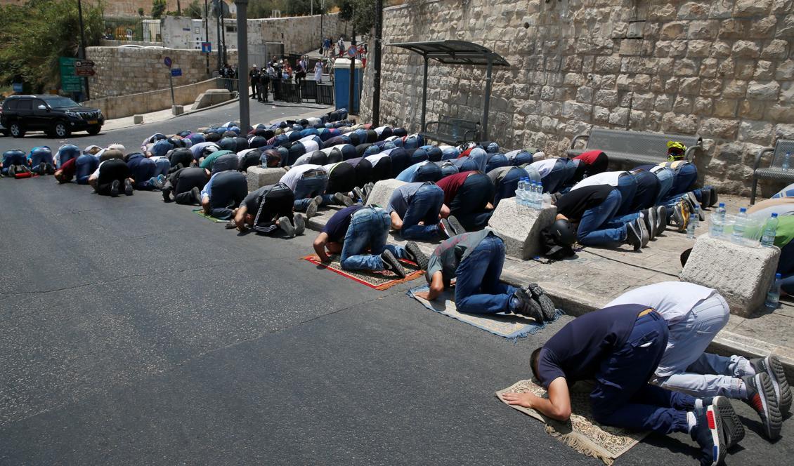 
Palestinska muslimer ber utanför Lions port, huvudingången till Al-Aqsa-moske i Jersalems gamla stad den 22 juli 2017. Protester mot israeliska säkerhetsåtgärder efter en attack mot israeliska poliser orsakar våldsamma sammandrabbningar. Foto:  Ahmad Gharabli / AFP / Getty Images                                            