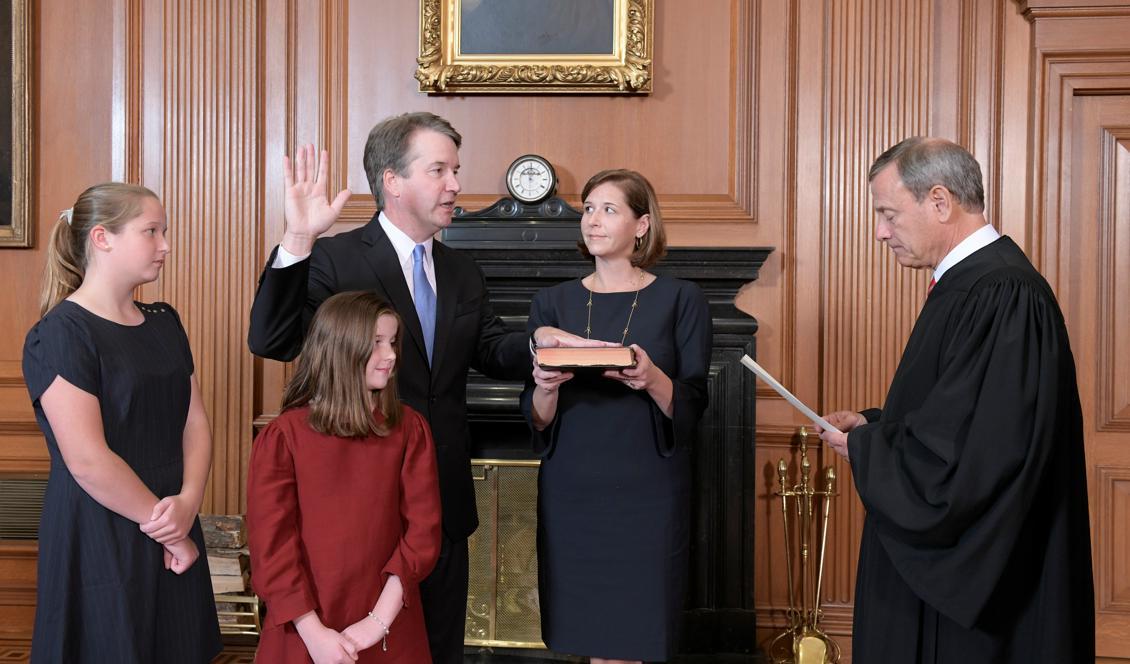 Brett Kavanaugh, i sällskap av döttrarna Liza och Margaret samt hustrun Ashley, svärs in som domare i USA:s högsta domstol av HD:s chefsdomare John Roberts. Foto: Fred Schilling/US Supreme Court/Handout/Reuters/TT