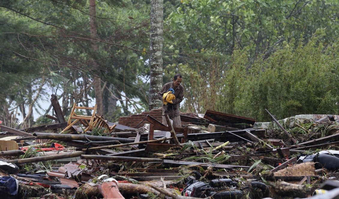 En man betraktar på julaftonsmorgonen det som tidigare var hans hem nära byn Sumur i Indonesien. Foto: Tatan Syuflana/AP/TT