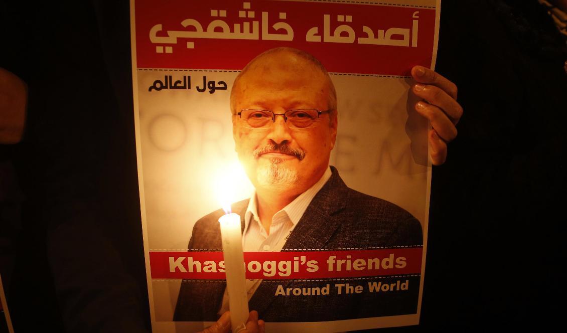 En bild på den mördade saudiske journalisten Jamal Khashoggi hålls upp under en minnesstund för honom utanför det saudiska konsulatet i Istanbul i oktober i fjol. Foto: Lefteris Pitarakis/AP/TT-arkivblid