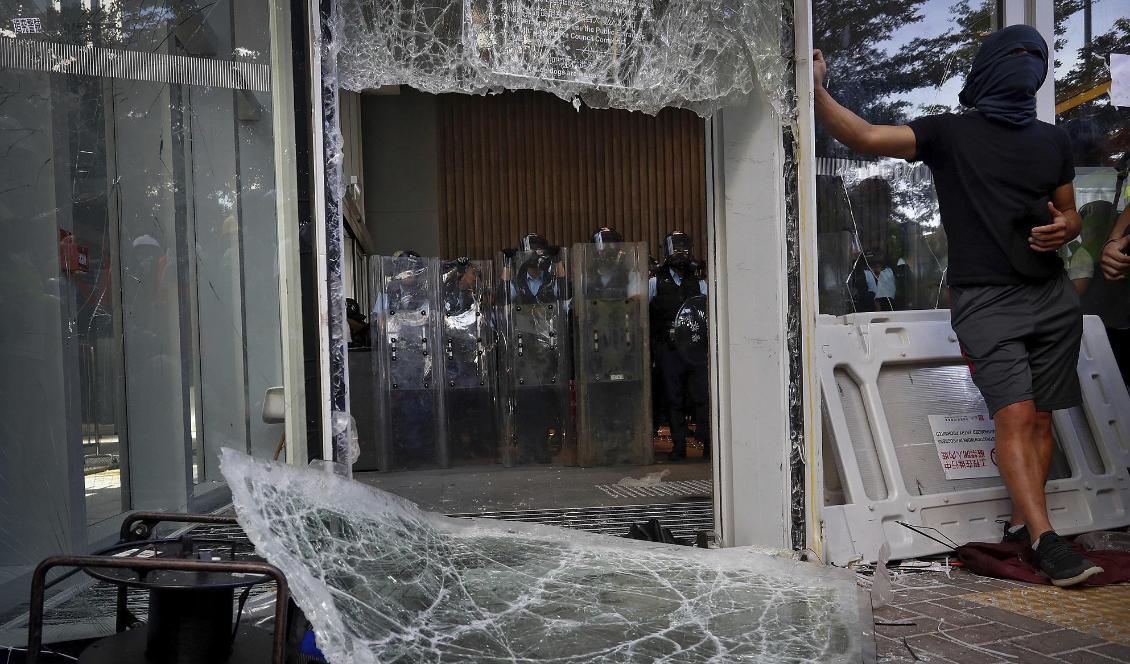 Demonstranter lyckades krossa säkerhetsglaset vid det lagstiftande rådet. Innanför väntade kravallpolis. Foto: Vincent Yu/AP/TT