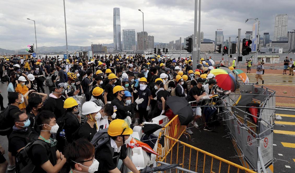 Demonstranter blockerar en väg i Hongkong. Foto: Kin Cheung/AP/TT