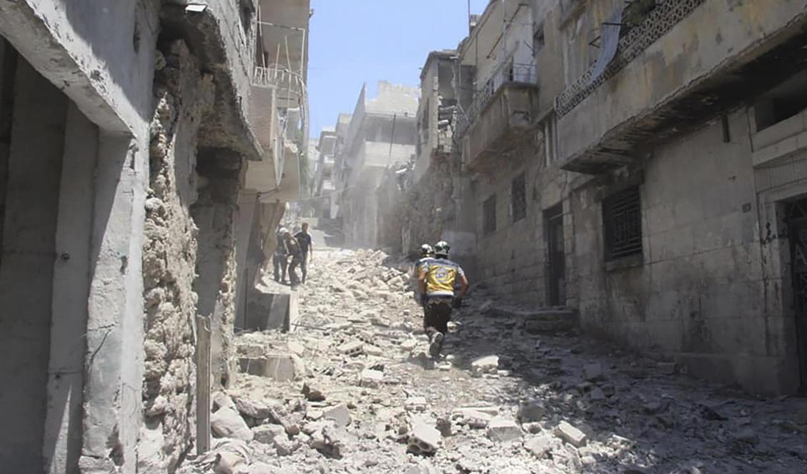 Ett foto som distribuerats av civilförsvarsorganisationen Vita hjälmarna i Idlib visar räddningsarbetare i staden Jisr al-Shughur efter ett luftangrepp på torsdagen. Foto: Vita hjälmarna via AP/TT