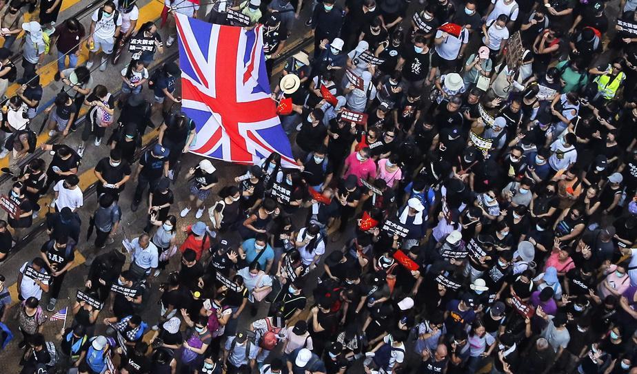 Den brittiska flaggan viftades under protesterna i Hongkong på söndagen. Foto: Kin Cheung/AP/TT