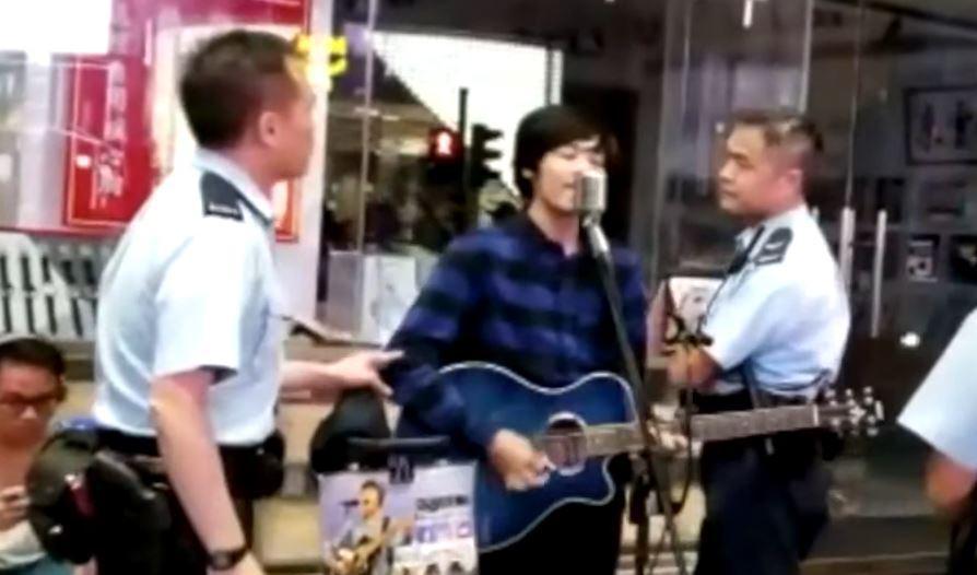 

Poliser försöker få en gatumusiker att avbryta sitt framträdande i Hongkong, oktober 2019. Foto: Skärmavbild/YouTube                                                                                                