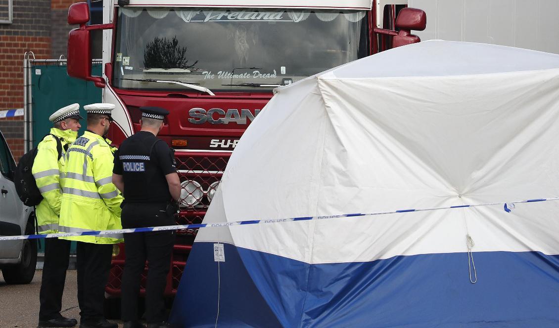 Poliser vid lastbilen som containern var kopplad till när kropparna upptäcktes. Foto: Alastair Grant/AP/TT-arkivbild