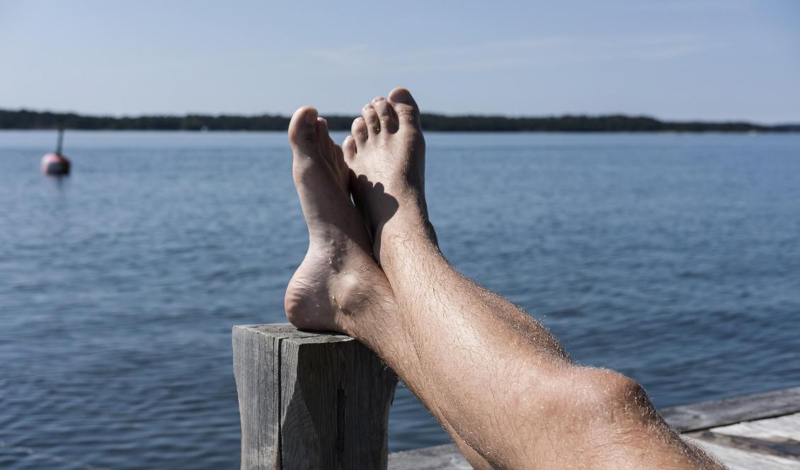 En man ligger och solar på en brygga i Stockholms skärgård. Foto: Vilhelm Stokstad/TT-arkivbild