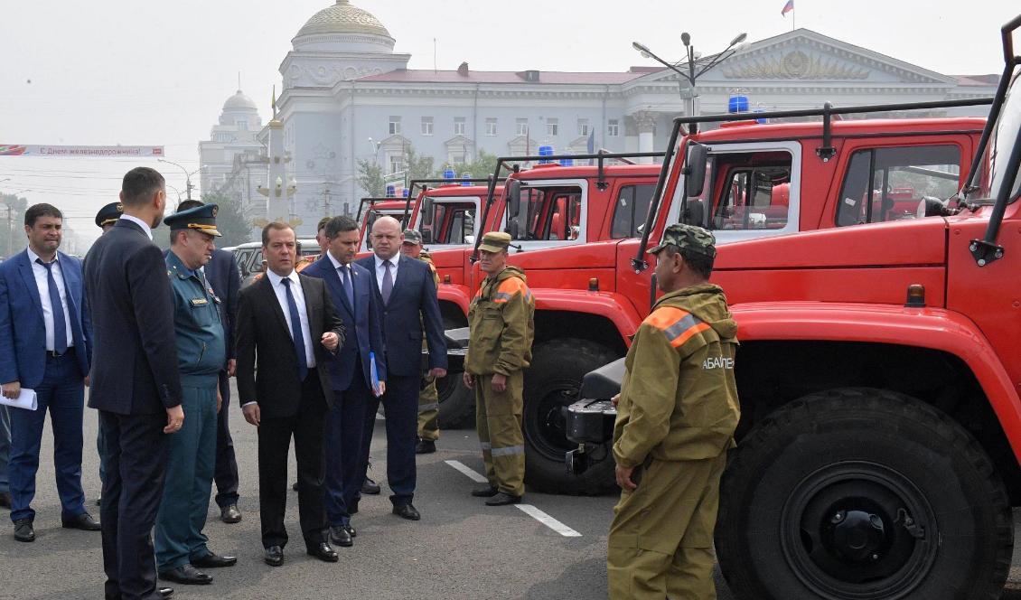 Rysslands premiärminister Dmitrij Medvedev inspekterar brandfordon på Lenintorget i Tjita i södra Sibirien. Foto: Alexander Astafyev/AP/TT