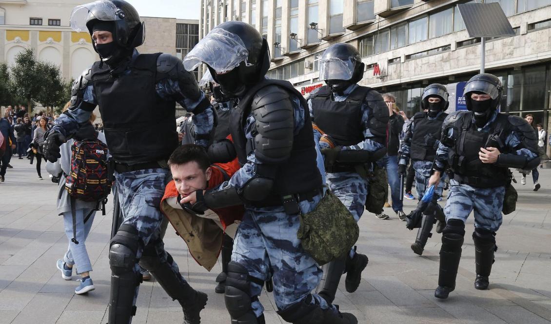Poliser släpar bort en demonstrant under lördagens protester i Moskva. Foto: Alexander Zemlianichenko/AP/TT