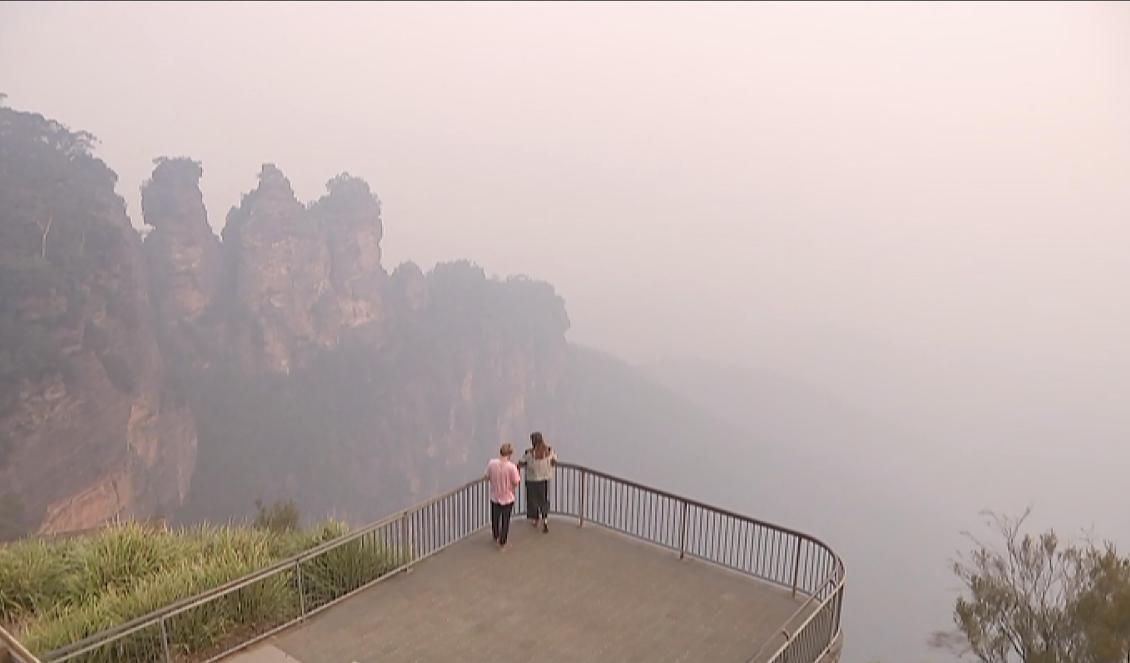 Klippformationen "Three sisters" i närheten av Katoomba insvept i brandrök på en bild tagen i måndags. Foto: AP/TT