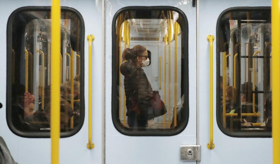 En kvinna med munskydd i tunnelbanan i Milano.  Foto: Antonio Calanni/AP/TT-arkivbild