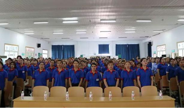 

Öppningsceremoni för nattundervisning i mandarin vid skofabriken Taekwong i Qingdao, där uigurer tillverkar skor för Nike. Foto: Skärmavbild/arkiv WeChat 1 juli 2019                                                                                            