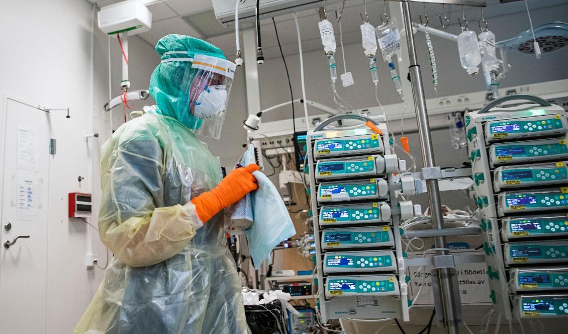 

En sjuksköterska, som bär skyddsutrustning och ansiktsmask, tar hand om en covid-19-patient i Karolinska sjukhuset i Solna den 19 april 2020. Foto: Jonathan Nackstrand/AFP via Getty Images                                                                                                