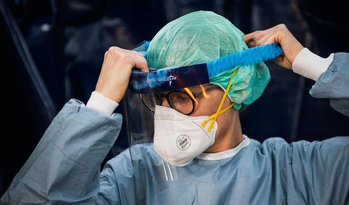 
Sjuksköterskan Renee Jarvalt tar på sig skyddsutrustning i ett tält vid Sophiahemmet  i Stockholm den 22 april 2020. Foto: Jonathan Nackstrand/AFP via Getty Images                                                